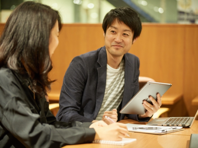 記事の相談をしている男女